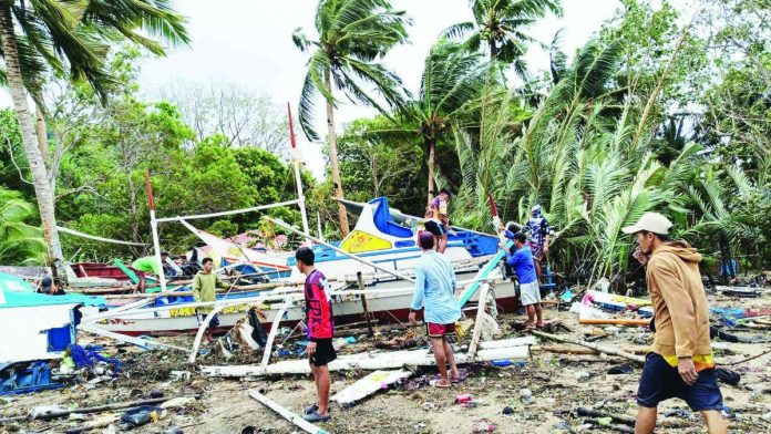 ime_more_boats_resized_compressed AFTERMATH OF THE WAVES. Fishermen inspect and salvage damaged fishing boats along the coastline of Concepcion, Iloilo after strong waves battered the area over the weekend, leaving hundreds of boats wrecked or partially destroyed and disrupting the livelihood and transport of island communities. PHOTO CONTRIBUTED BY AIROSE C. CALINAO
