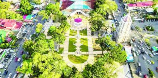This aerial view of Jaro Plaza shows the historic district’s central park framed by mature trees, the Jaro Belfry, and surrounding streets. No fiesta carnival will be held at the plaza during the February 2 Jaro Fiesta in honor of Nuestra Señora de la Candelaria. PHOTO FROM JERRY TREÑAS FACEBOOK PAGE