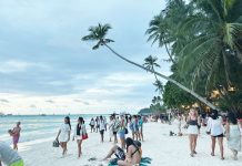 Tourists stroll along White Beach in Boracay Island as authorities warn travelers to transact only with accredited tourism operators amid a rise in unregistered and online scam-prone tourism service providers. PHOTO FROM X