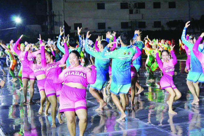 RAIN OR SHINE SPIRIT. Despite a rain-soaked and slippery dance platform, dancers from the competing tribes push through with energy and smiles as they take part in the “Unity Dance” during the opening salvo of Kasadyahan sa Kabanwahanan at the Iloilo Sports Complex on Saturday, January 10. Heavy downpour later forced organizers to cancel the remaining performances to ensure the safety of the performers. AJ PALCULLO/PN