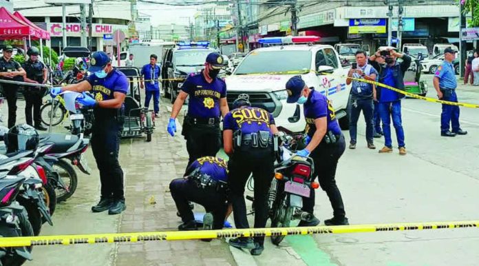 neljoy_shooting_scene_resized_compressed Crime scene investigators collect evidence at the corner of Delgado and Mabini streets in Iloilo City after a shooting incident involving two security guards on Monday morning, January 5, 2026. AJ Palcullo/PN