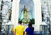 Devotees pause in silent prayer before the image of Nuestra Señora de la Candelaria at her outdoor niche in the Jaro Metropolitan Cathedral, offering petitions and thanksgiving in an intimate moment of faith. AJ PALCULLO/PN