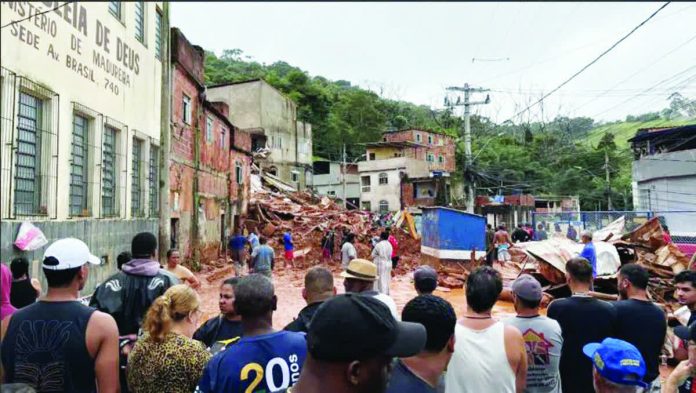 Brazil_copy_resized_compressed People stand and watch as rescue workers search for missing residents after a landslide in the Brazilian state of Minas Gerais. REUTERS