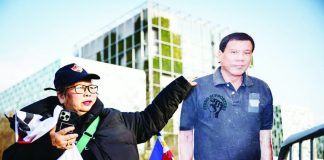 A person stands by a life-size cartboard cutout of former Philippine president Rodrigo Duterte during a demonstration outside the International Criminal Court in The Hague, Netherlands. AFP