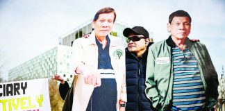 A supporter stands by two life-size cardboard cutouts of former Philippine president Rodrigo Duterte outside the International Criminal Court in The Hague, Netherlands. AFP