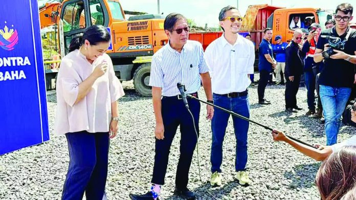 Marcos_sets_aside_copy_resized_compressed President Ferdinand Marcos Jr. shows his pink socks to reporters as former Vice President Leni Robredo, incumbent Naga City mayor, and Public Works Secretary Vince Dizon react during Marcos’ visit to Naga on February 21, 2026. PHOTO BY MICHAEL B. JAUCIAN, PHILIPPINE DAILY INQUIRER