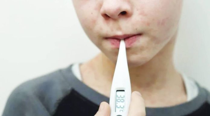 The United Kingdom was first declared measles-free in 2017, but lost the status two years later, before regaining it after spread of the virus was almost halted completely in 2021 - although that was mainly because social distancing during the pandemic. Photo shows a boy suffering from measles checking his temperature with a thermometer. GETTY IMAGES