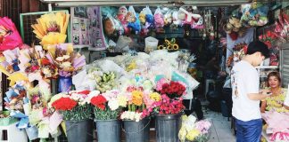Flower vendor Mary Grace Gabrido assists customers picking out flowers for Valentine's Day at her shop on Iznart Street in Iloilo City. She says the business that once comfortably sustained her family now faces a tougher landscape, pointing to the surge of online sellers that have reshaped the floral trade. NELJOY GALIGAO/PN