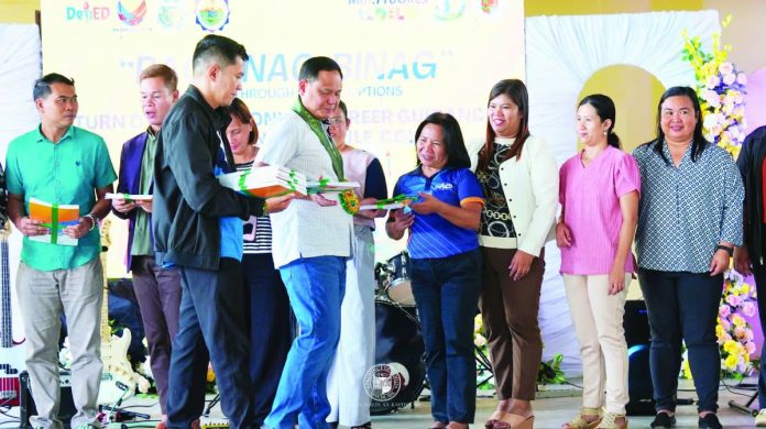 ime career copy_compressed CAREER PATHWAY BOOST. Gov. Arthur Defensor Jr. (foreground, second from left) leads the turnover of Career Guidance Instructional Modules (CGIM) to representatives of 80 public secondary schools during the “Pagbinag-binag: Thinking Through Career Options” activity at Pavia National High School, marking Iloilo’s rollout of a province-wide program aligning senior high school education with workforce demands. PHOTO COURTESY OF BALITA HALIN SA KAPITOLYO