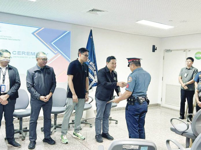 Office for Transportation Security undersecretary Gilbert DC Cruz presents a commendation to a Philippine National Police – Aviation Security Unit 6 officer during a simple awarding ceremony at the Iloilo International Airport, recognizing the unit’s swift and heroic response in neutralizing an unruly, armed passenger. PNP AVSEGROUP AVSEU6 FACEBOOK