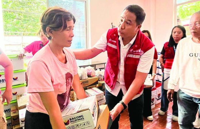 ime_family_copy_resized_compressed Department of Social Welfare and Development – Region 6 director Joselito Estember personally assists and speaks with a fire victim during the distribution of relief goods at the evacuation center in Barangay Benedicto, Jaro, Iloilo City, following the blaze that displaced more than 100 families. DSWD-6