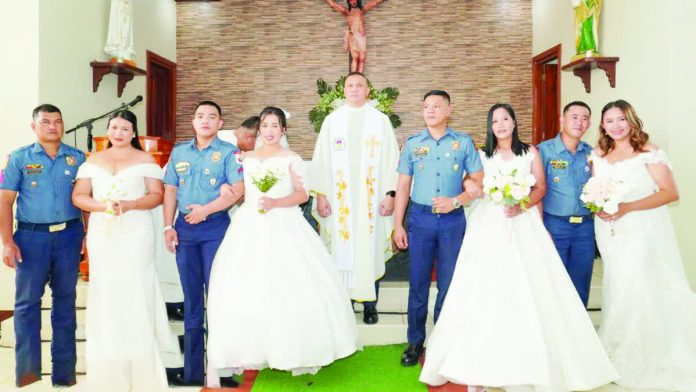 Four police couples exchanged vows during a mass wedding ceremony officiated by Police Brigadier General Jaime C. Seriña III at Saint Michael the Archangel Chapel inside Camp Alfredo M. Montelibano Sr. in Bacolod City on February 20. PRO-NIR PHOTO