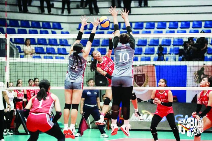 San Beda University Lady Red Spikers’ Janelle Bachar unloads a spike against two Lyceum Lady Pirates defenders during their straight-sets victory in NCAA Season 101 women’s volleyball at the San Andres Sports Complex. NCAA PHOTO