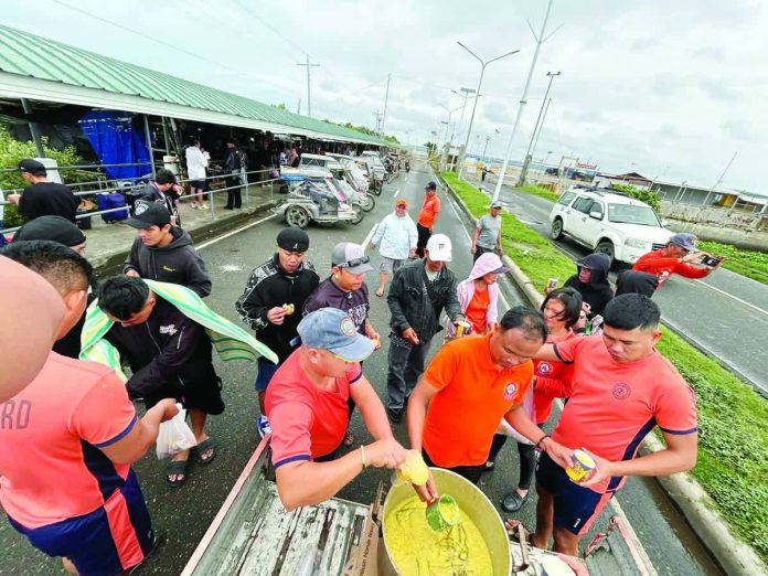 stranded_resized_compressed Officers of the Coast Guard Station Iloilo distributed hot meals to stranded passengers at Dumangas Port in Dumangas, Iloilo, on Friday, Feb. 6, 2026. The Coast Guard District Western Visayas recorded 1,292 stranded passengers, drivers, and cargo helpers as of 12 noon Friday due to the continued suspension of sea trips across the region due to Tropical Depression “Basyang.” COAST GUARD STATION ILOILO PHOTO