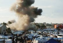 Gaza peace doubts deepen as attention shifts to Iran Smoke can be seen rising behind a tent camp following an Israeli strike in the central Gaza Strip. REUTERS