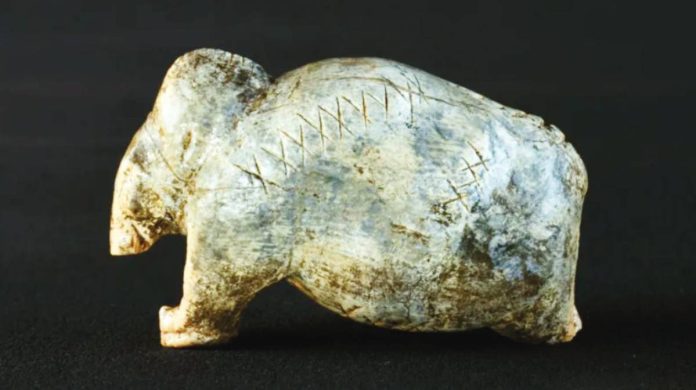 A 40,000-year-old mammoth figurine has deeply-engraved rows of crosses and dots. UNIVERSITY OF TÜBINGEN / HILDEGARD JENSEN