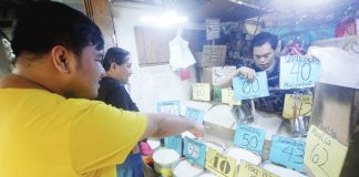 Customers buy rice priced from P40 to P65 per kg. at a stall at the Paco Public Market in Manila. The Department of Agriculture is considering a P50-per-kg. price cap on imported rice to temper rising costs, with prices in some markets reaching P60 to P65 due to higher freight rates linked to the Middle East conflict. PNA
