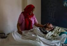 Harish Rana’s mother pats him lying in a bed. Rana has been in a vegetative state since 2013 after falling from a fourth-floor balcony. BBC/RANA FAMILY