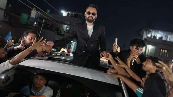 Nepal_compressed_resized Balendra Shah standing out of a car’s sunroof as he takes supporters’ hands who are gathered around the car. He is celebrating with supporters after defeating Nepalese Prime Minister Sharma KP Oli. REUTERS