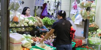 A customer browsing goods inside a market stall.