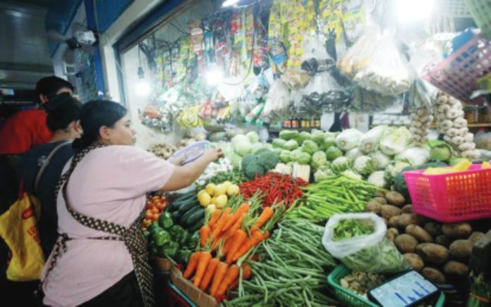 economist sees copy A market vendor arranges fresh produce in this undated photo. An economist forecasts domestic inflation rate to break the 4 percent level this year as oil prices in the international market nears USD100 per barrel because of the conflict in the Middle East. PNA FILE PHOTO BY YANCY LIM