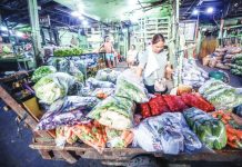 Firms hold line on prices as gov’t ramps up fuel measures A vendor inspects newly delivered vegetables at a market in Quezon City. The Philippines will remain food secure despite the ongoing tension in the Middle East because of sufficient supply of agricultural commodities, particularly rice, the Department of Agriculture says. PNA