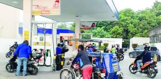 Riders queue at a gas station in Quezon City. The government has warned gasoline stations against imposing unjustified price increases. PNA