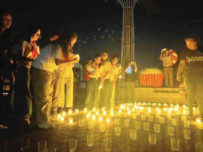 ime Earth Hour copy LIGHTS OUT, HOPE ON. Participants light candles at the Iloilo Provincial Capitol grounds during Earth Hour 2026: “Ligum Dulom Year 4”, symbolizing collective action and renewed commitment to energy conservation and environmental protection. PHOTOS FROM PGENRO-PROVINCE OF ILOILO