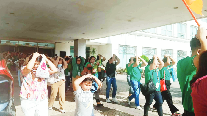 ime drill (1) copy Emergency responders carry a simulated victim out of the Iloilo Provincial Capitol while employees and visitors evacuate using the “duck, cover, and hold” protocol during the first quarter Nationwide Simultaneous Earthquake Drill conducted by the Provincial Disaster Risk Reduction and Management Office on March 12, 2026. The exercise aimed to strengthen earthquake preparedness and response among government workers and the public. IME SORNITO/PN