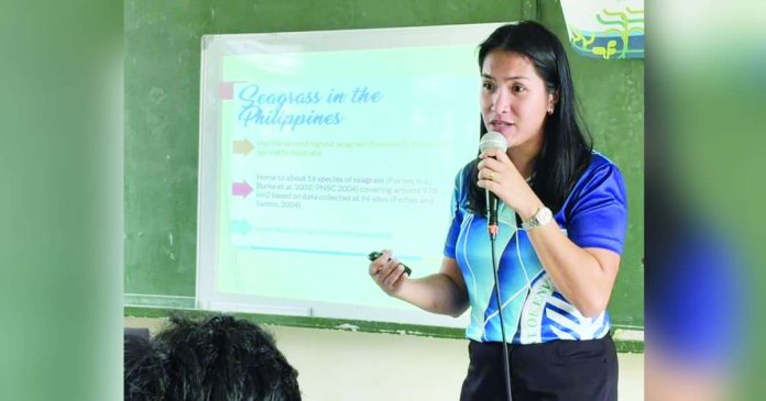 neljoy environment (1)_superimposed Environmental Specialist Grace Aquino explains how seagrasses function as carbon sinks that help mitigate climate change, nurseries that support diverse marine life, and natural barriers that shield coastlines from erosion and extreme weather events, during a special environmental learning activity in Ajuy, Iloilo. DENR-6 PHOTO