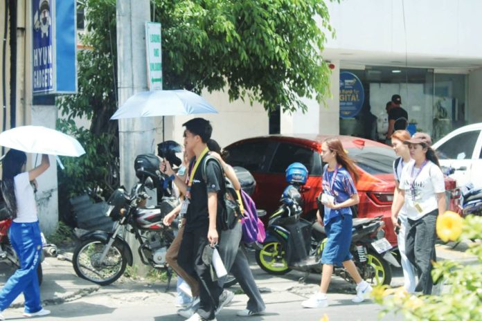 neljoy heat-related In Iloilo City, many people use umbrellas to shield themselves from intense heat while walking along busy streets. The Department of Health urges the public to stay alert and take precautions against heat-related illnesses. AJ PALCULLO/PN