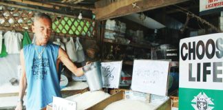 Veteran rice retailer Antonio Parparan attends to his stall in Pavia, Iloilo, reporting a P50 increase per sack and steady demand despite rising prices, as customers continue to rely on rice as a staple. AJ PALCULLO/PN