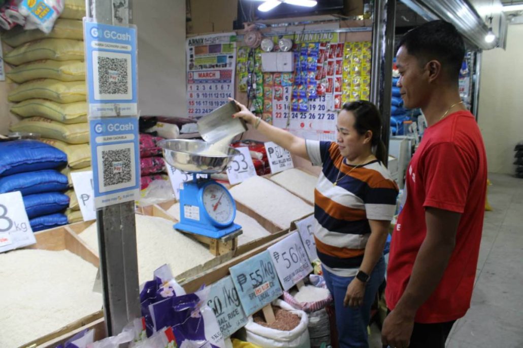 Bing Cachuela scoops rice for customers at La Paz Public Market in IIoilo City as she navigates daily price fluctuations, saying suppliers’ rising costs force retailers to adjust prices just to avoid losses. AJ PALCULLO/PN