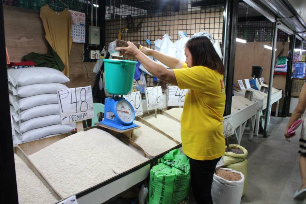 A rice retailer in Pavia, Iloilo measures out rice as prices continue to climb. Every new delivery comes with higher costs, prompting increases of P4 to P5 per kilo, she says. AJ PALCULLO/PN