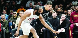 Cleveland Cavaliers guard James Harden aims for the ball while Brooklyn Nets forward Michael Porter Jr. looks on. AP