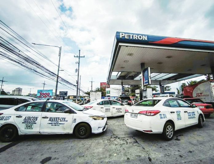 tax cut copy Cab drivers queue at a gasoline station in Quezon City, aware of rising fuel prices. President Ferdinand Marcos Jr. will formally ask Congress for emergency powers to reduce excise tax on petroleum products amid the crisis in the Middle East, Malacañang says. PNA