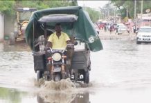 A motorized delivery trike makes its way through flooded waters in Angola. EVN