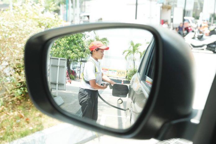 DOE copy FRONTLINE DUTY. A female worker refuels a vehicle at a gasoline station along Tomas Morato Avenue in Quezon City. Since global oil market forces remain the primary driver of pump costs, the Department of Energy says the newly secured safe passage arrangement for Philippine vessels through the Strait of Hormuz in Iran will not immediately translate into lower fuel prices. PNA