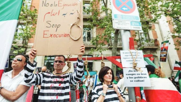 Two people dressed as hanged prisoners, with painted blood on their faces and nooses around their necks, take part in a protest against executions in Iran by opponents of the Islamic Republic, outside the US embassy of Madrid, Spain. GETTY IMAGES