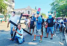 BIBLICAL-LEVEL SUFFERING. A jeepney driver bears a wooden cross along a busy Iloilo City street, dramatizing the crushing burden of soaring fuel prices as protesters liken the daily struggle of commuters and drivers to Christ’s suffering at Calvary. BAYAN-PANAY PHOTO
