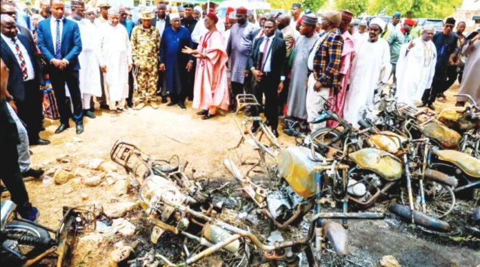 A group of men and officials look on at the burnt-out remnants of motorbikes Adamawa State Government I Nigeria. Gunmen have killed at least 29 people in an attack on a community in Nigeria's north-eastern Adamawa state. ADAMAWA STATE GOVERNMENT