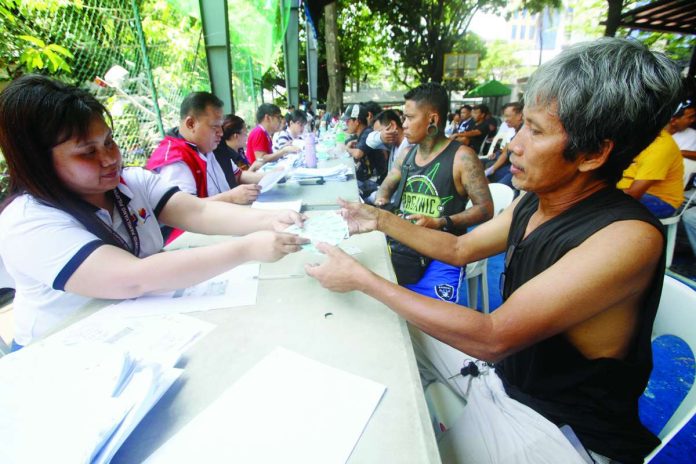 e-wallets_copy_compressed_resized AID FOR DRIVERS. Department of Social Welfare and Development personnel distribute P5,000 cash assistance to tricycle and public utility jeepney drivers during a payout at the Dakota Covered Court in Malate, Manila. The assistance aims to alleviate the financial burden on drivers amid rising fuel prices, ensuring they can continue providing essential transportation services to the community. PNA