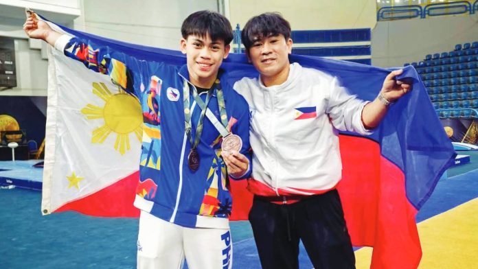 eldrew Karl Eldrew Yulo (left) celebrates with a Gymnastics Association of the Philippines coach after capturing two bronze medals -- horizontal bar event and floor exercise -- at the 2026 Artistic Gymnastics World Cup. GAP PHOTO