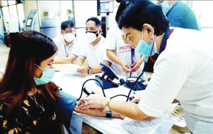 A nurse checks the blood pressure of a patient during a medical mission in Quezon City. The Philippine Institute for Development Studies says local government units spend only about P850 per capita on average on health and nutrition programs, falling well short of the estimated P1,827.8 per person annually needed to deliver essential primary healthcare services. PNA