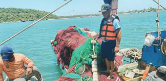 Regional Director Remia Aparri (right photo) of the Bureau of Fisheries and Aquatic Resources in Western Visayas says that while progress has been made in curbing illegal fishing across the region, some operators have resorted to “front” operations and forged permits to evade law enforcement. Left photo shows a fishing boat apprehended for illegal operations in Barangay Olotayan, Roxas City, last March. RADYO MARAGTAS PHOTO