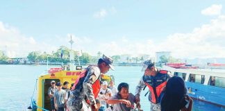 Philippine Coast Guard personnel assist passengers from Guimaras Island as they disembark from a motorboat upon arrival at a wharf in Iloilo City. Authorities are intensifying port operations for the Holy Week travel surge. PCG-ILOILO PHOTO