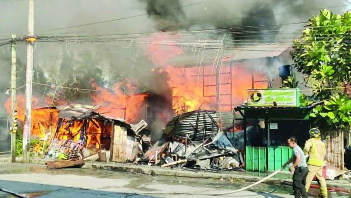 neljoy_Pavia_fire_copy_compressed_resized RAGING INFERNO. Fire engulfs a residential structure in Barangay Purok II, Pavia, Iloilo on Sunday morning, April 19, 2026, rapidly spreading to nearby establishments as thick smoke billows into the sky. The blaze, fuelled by strong winds and extreme heat, caused over P224,000 in damage and prompted renewed calls from authorities for the public to report fires immediately instead of filming the incident for social media. AJ PALCULLO/PN