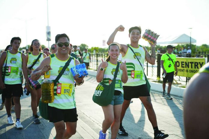 puregold2_compressed_resized A lively moment unfolds among friends taking part in the Hakot Relay, with various grocery items in hand.