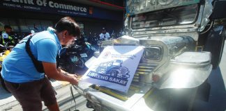 A driver puts a “Libreng Sakay” signage on his jeepney along Agoncillo Street in Manila. The city government of Manila pays a minimum P3,500 daily to participating drivers in exchange for providing free rides. PNA