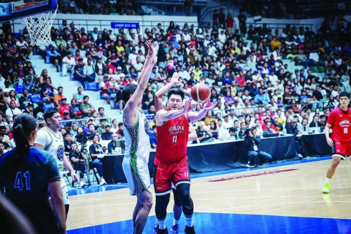 George Isaac Go Is forced to pass the ball while being defended by Terrafirma Dyip’s Geo Chiu. PBA PHOTO